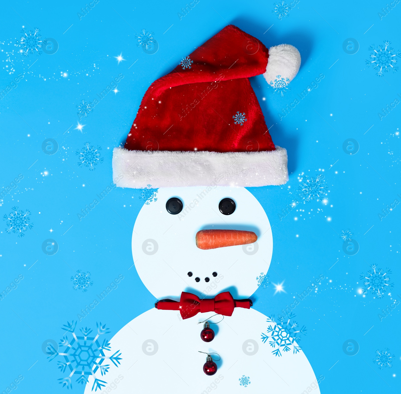 Image of Snowman with Santa hat and bow tie on light blue background, flat lay