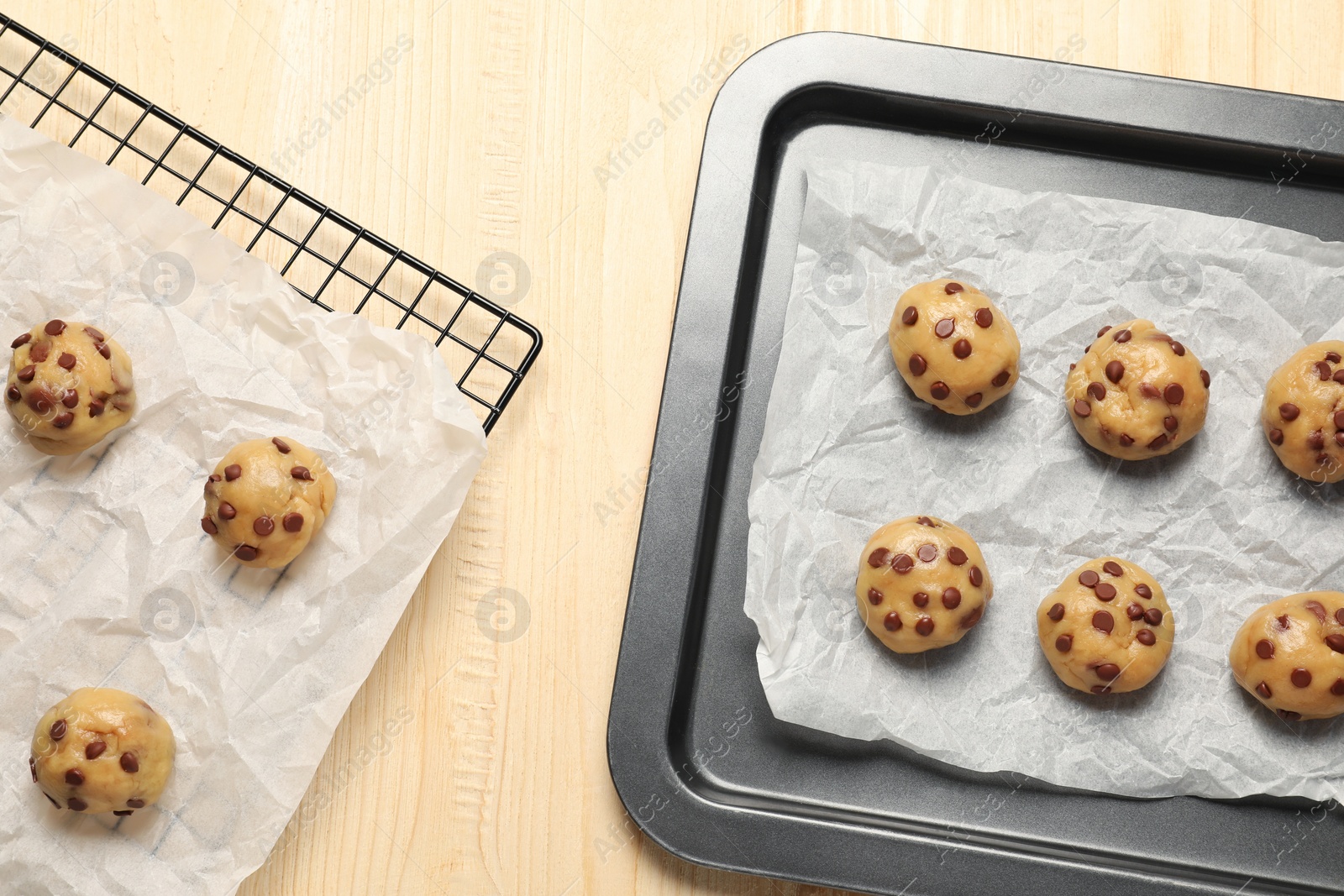 Photo of Uncooked chocolate chip cookies on wooden table, flat lay