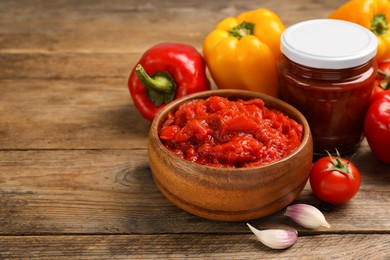 Delicious lecho and fresh vegetables on wooden table. Space for text