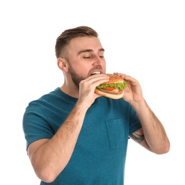 Photo of Young man eating tasty burger on white background