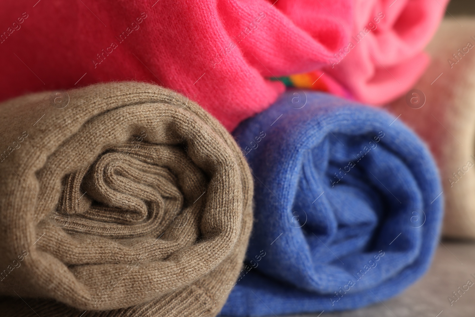 Photo of Closeup view of many rolled color sweaters