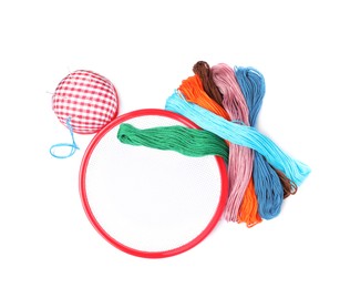 Photo of Colorful threads and different embroidery accessories on white background, top view