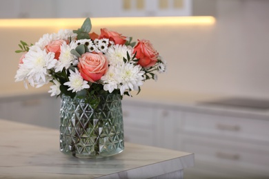 Photo of Vase with beautiful flowers on table in kitchen, space for text. Interior design