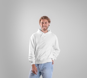 Photo of Portrait of man in hoodie sweater on light background. Space for design