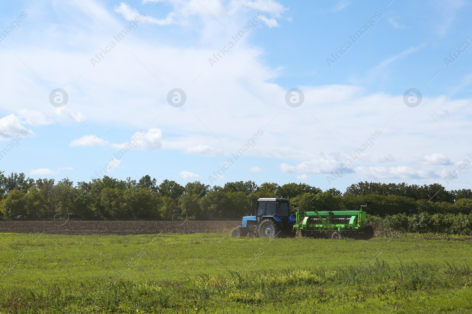 Photo of Modern tractor harvester in agricultural field on sunny day