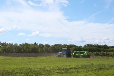 Photo of Modern tractor harvester in agricultural field on sunny day