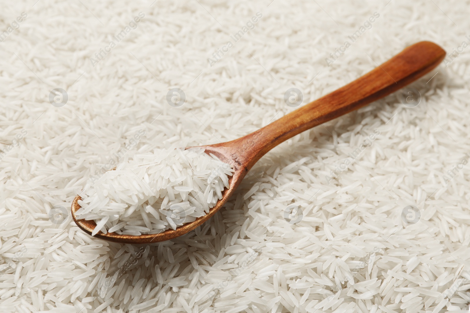 Photo of Raw basmati rice and spoon, closeup view