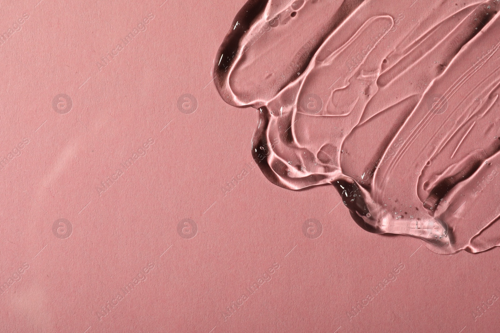 Photo of Transparent cosmetic gel on pink background, top view. Space for text