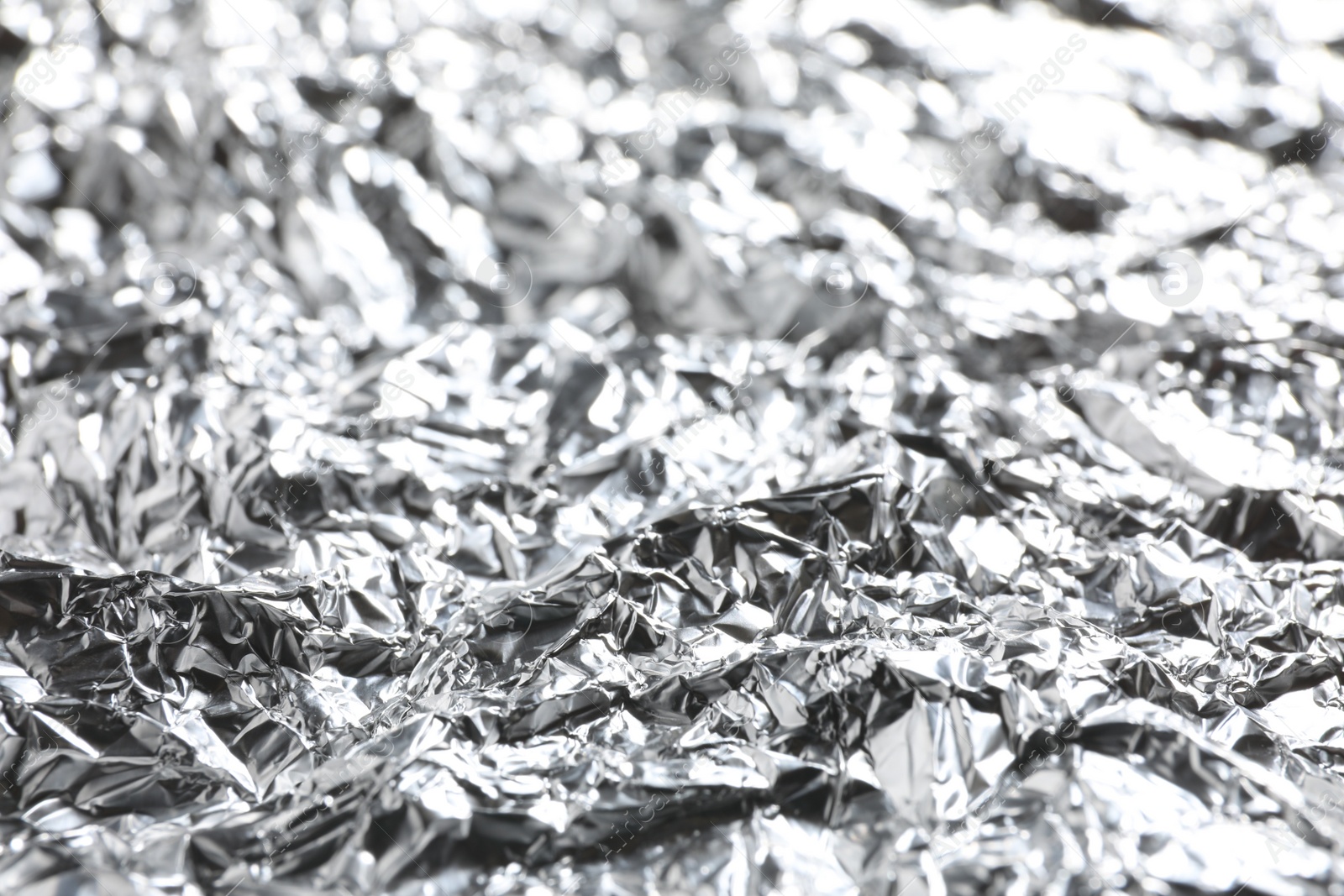 Photo of Crumpled silver foil as background, closeup view