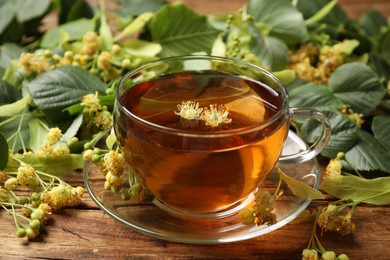 Cup of tea and linden blossom on wooden table