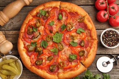 Photo of Delicious pizza Diablo, ingredients and cutter on wooden table, flat lay