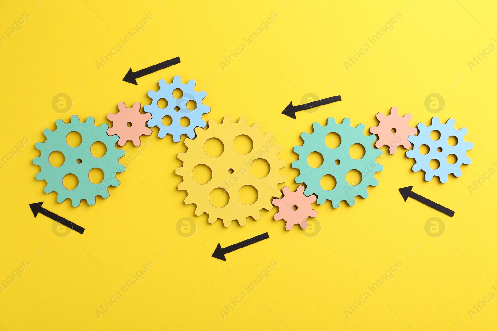 Photo of Business process organization and optimization. Scheme with wooden figures and arrows on yellow background, top view