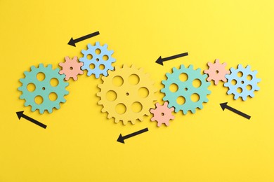 Business process organization and optimization. Scheme with wooden figures and arrows on yellow background, top view