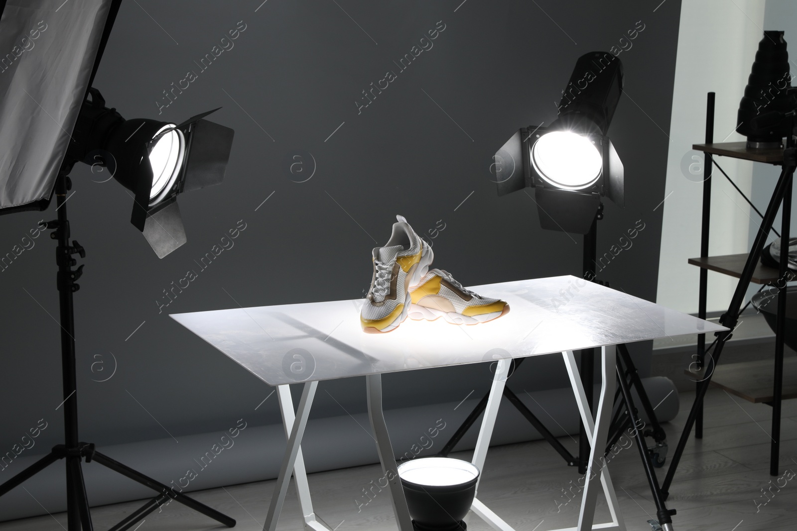 Photo of Professional photography equipment prepared for shooting stylish shoes in studio