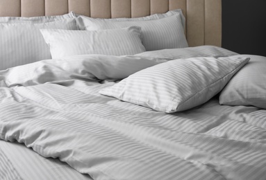 Photo of Comfortable bed with soft blanket and pillows, closeup