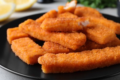 Photo of Fresh breaded fish fingers on plate, closeup
