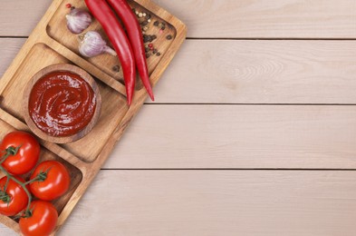 Plate with delicious ketchup in bowl, peppercorns and products on light wooden table, top view with space for text. Tomato sauce