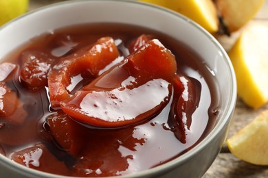 Tasty homemade quince jam in bowl on table, closeup