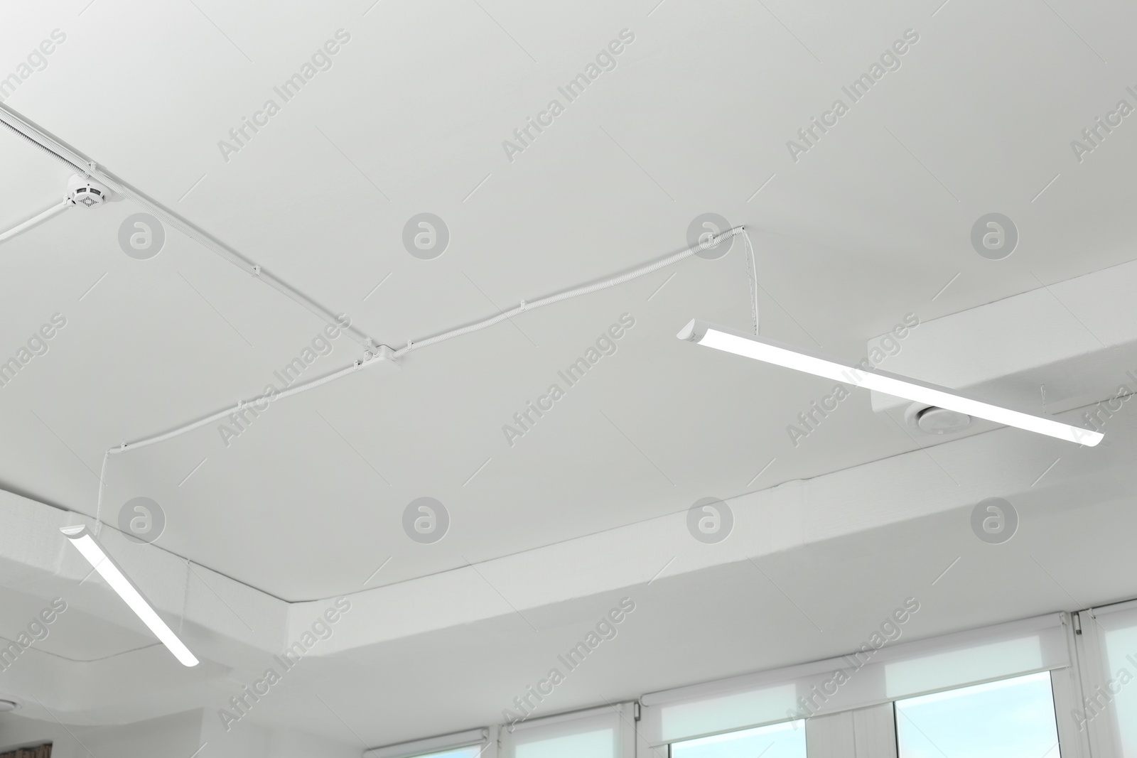 Photo of White ceiling with modern lighting in office
