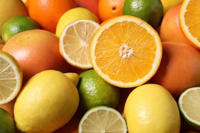 Photo of Different fresh citrus fruits as background, closeup