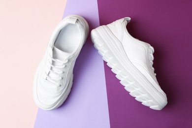 Photo of Pair of stylish sneakers on color background, top view