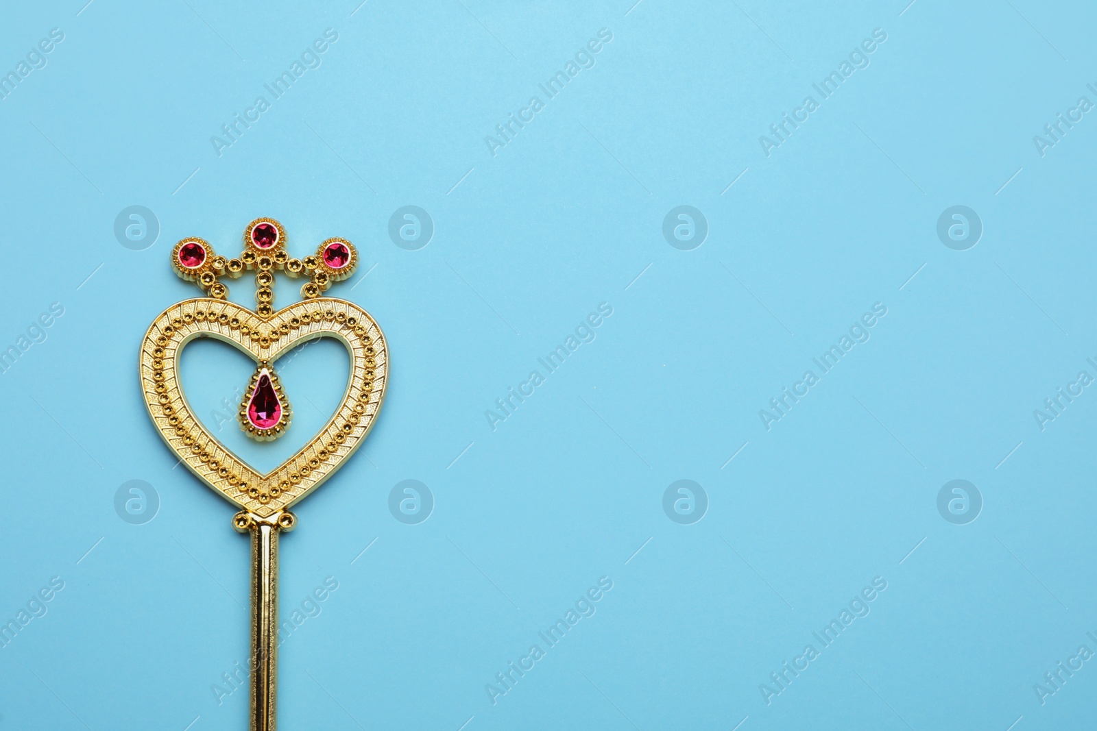 Photo of Beautiful golden magic wand on light blue background, top view. Space for text