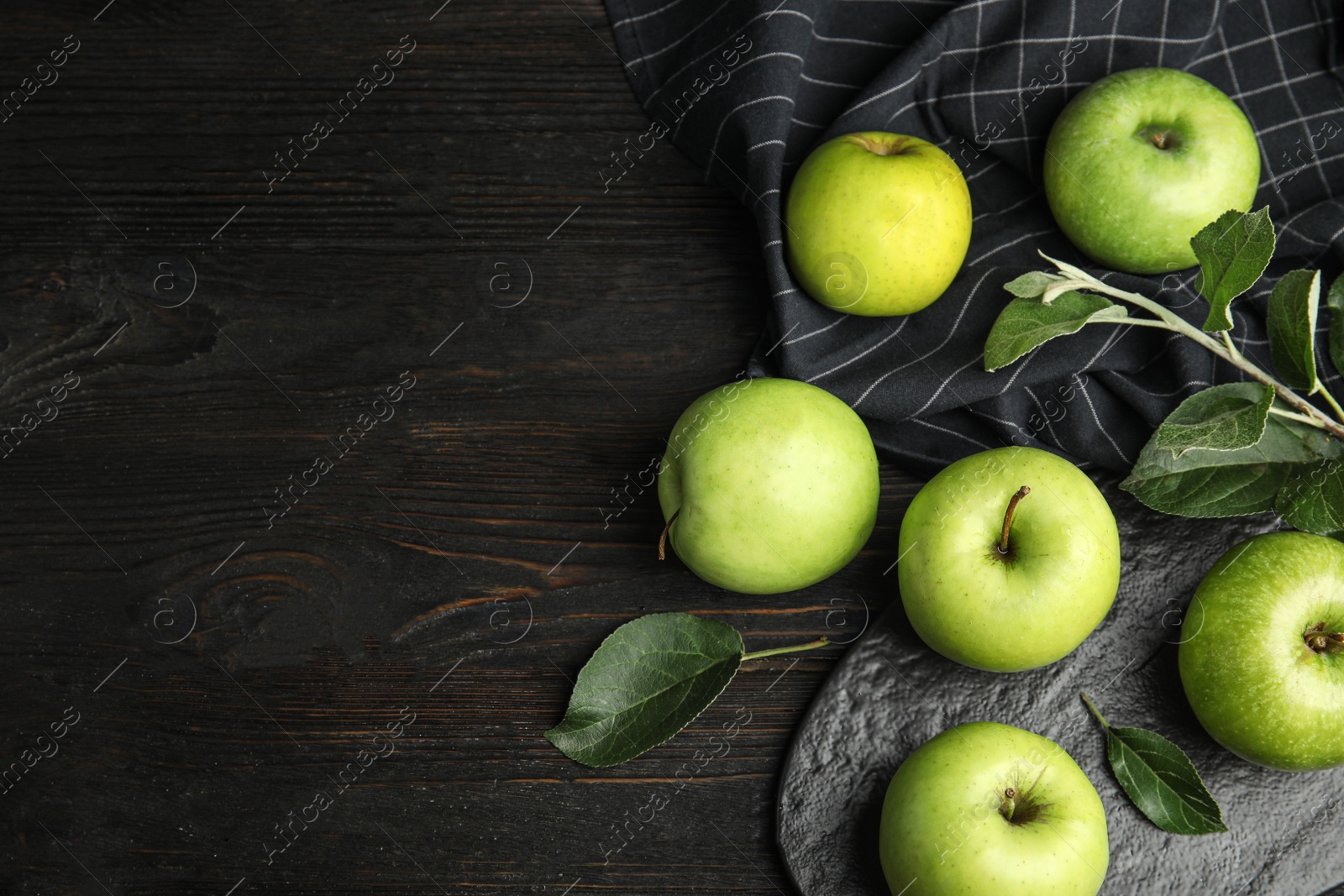 Photo of Flat lay composition of fresh ripe green apples on black wooden table, space for text