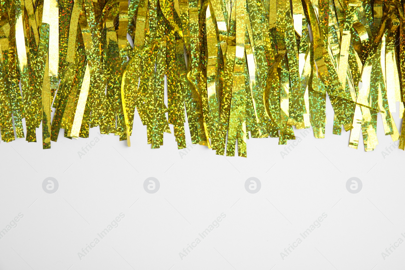 Photo of Golden tinsel on white background, top view. Space for text