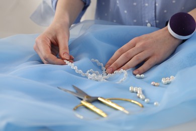 Photo of Dressmaker creating new dress in atelier, closeup