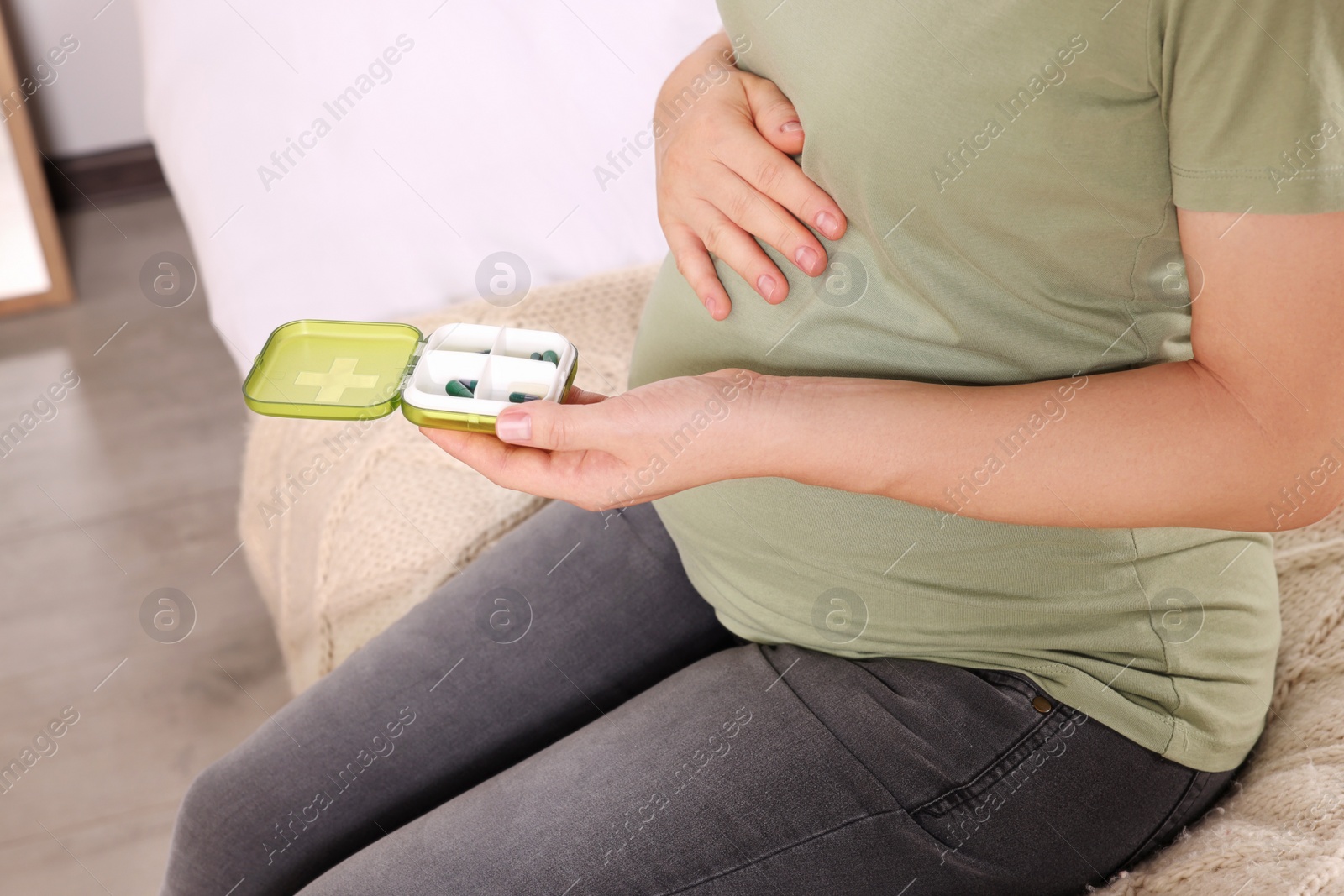 Photo of Pregnant woman taking pills at home, closeup