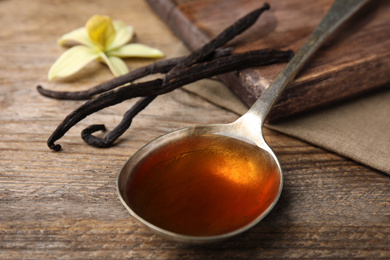 Aromatic homemade vanilla extract on wooden table, closeup