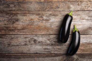 Photo of Raw ripe eggplants on wooden background, top view