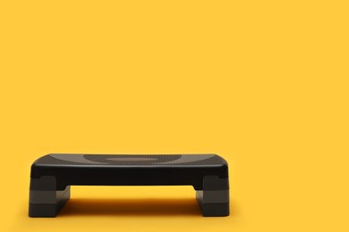 Photo of Step platform on yellow background, space for text. Sports equipment