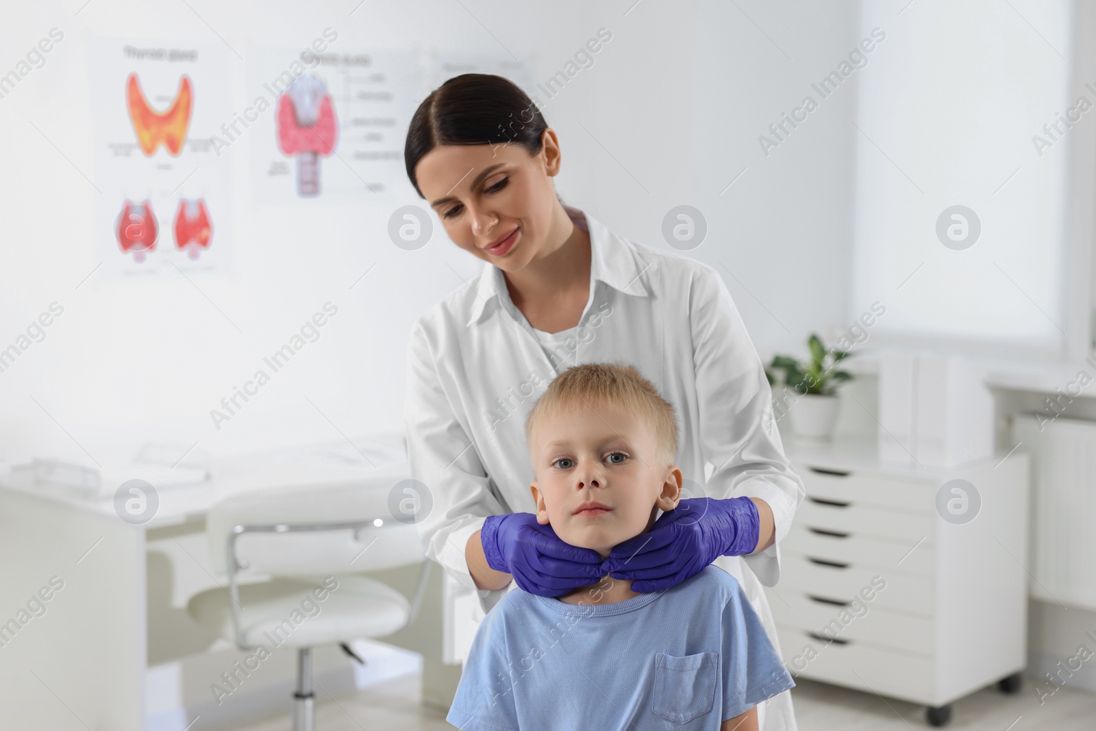 Photo of Endocrinologist examining boy's thyroid gland at hospital