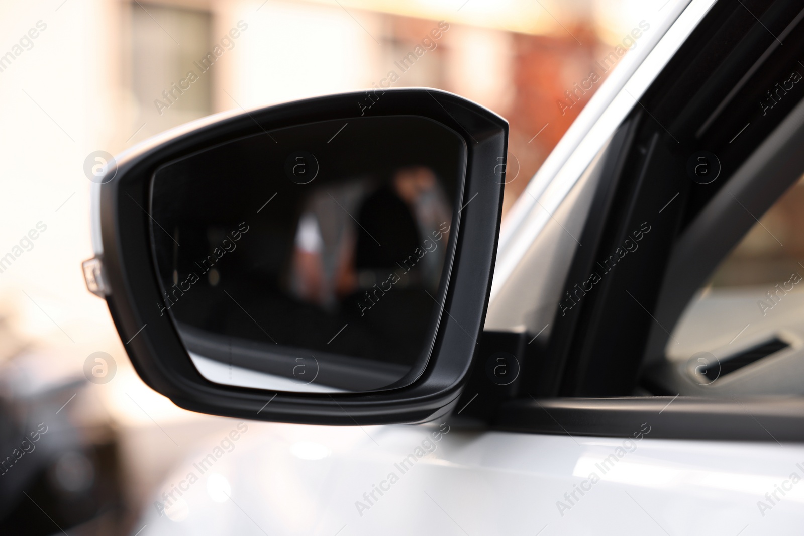 Photo of Side view mirror of modern car on blurred background, closeup