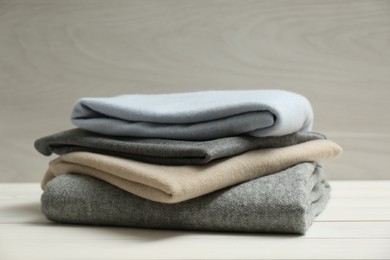 Stack of cashmere clothes on wooden table