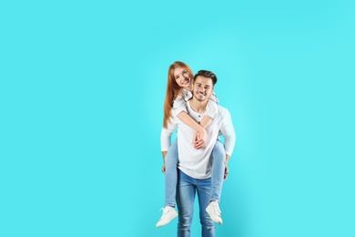 Photo of Young couple in stylish jeans on color background