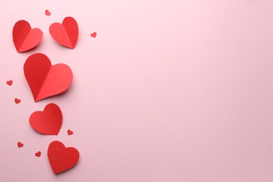 Photo of Paper hearts on pink background, flat lay. Space for text