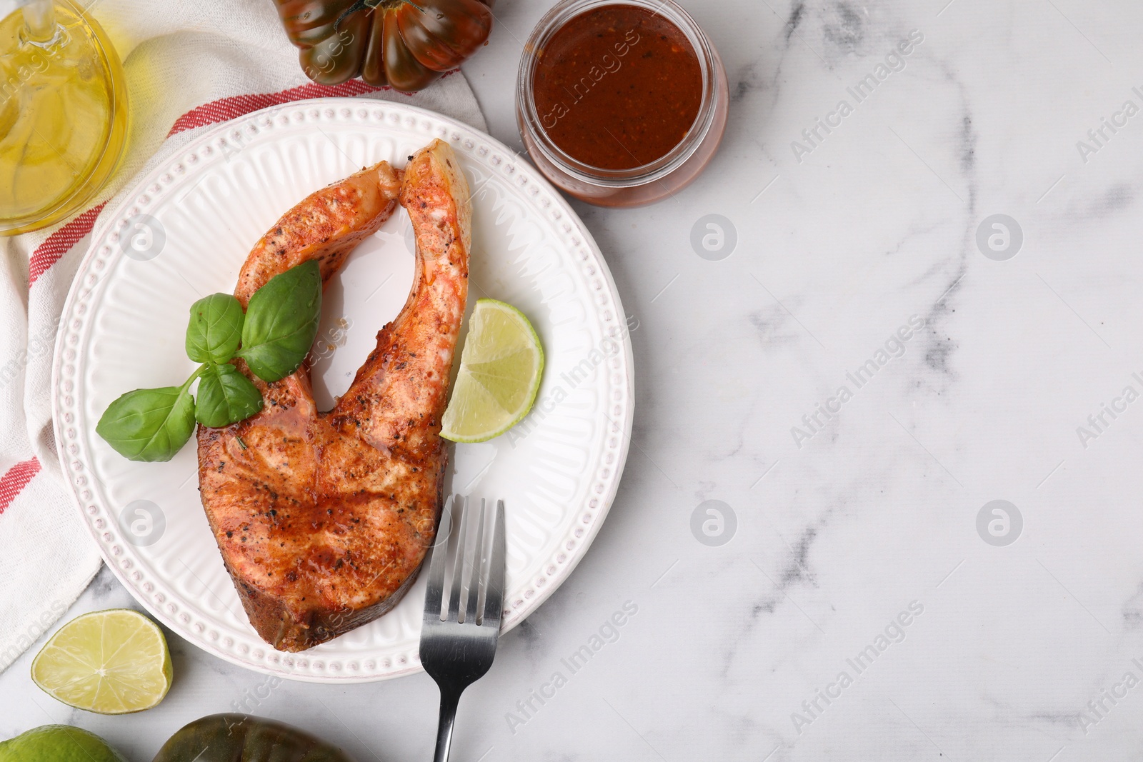 Photo of Fresh marinade, cooked fish and other products on white marble table, flat lay. Space for text