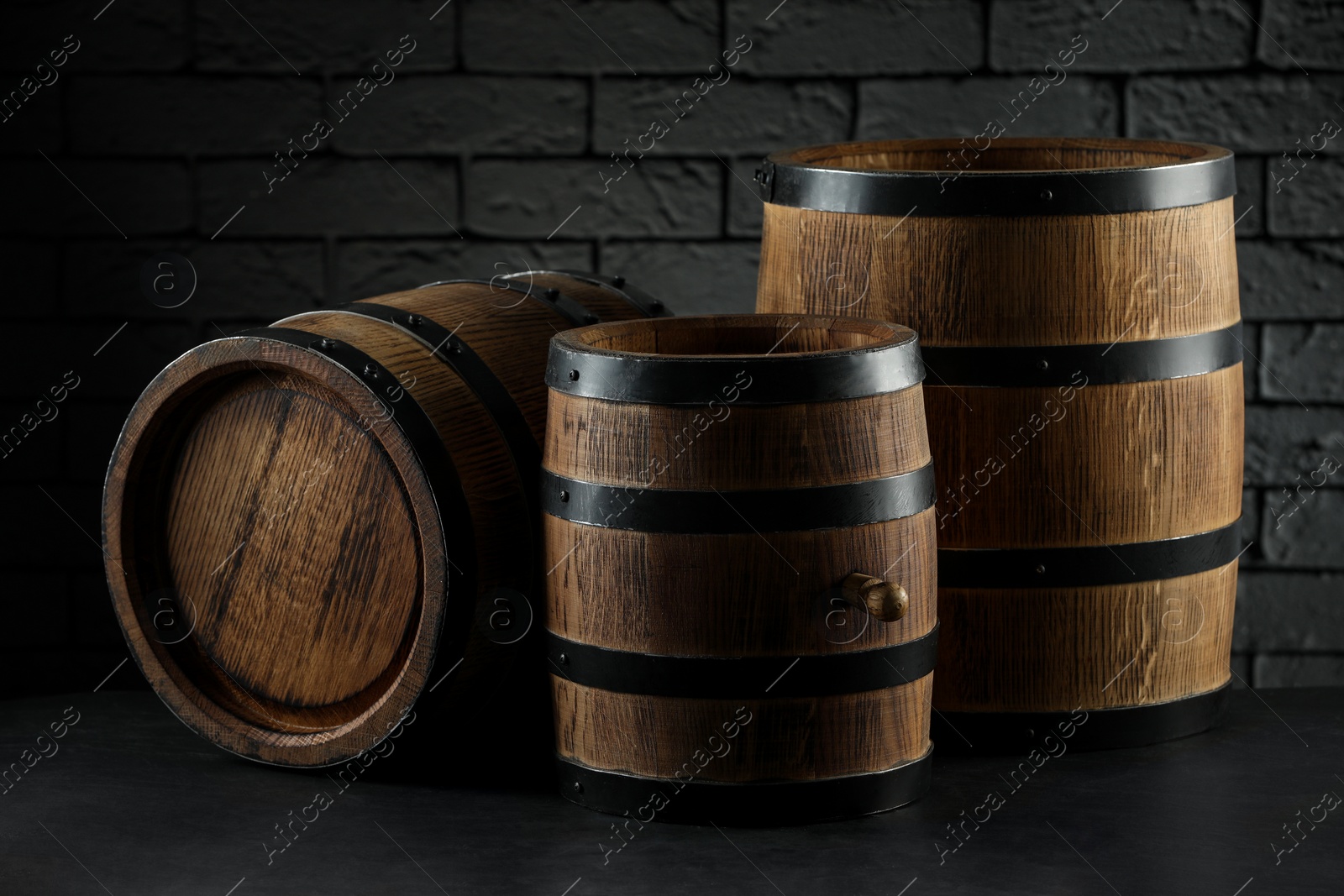 Photo of Wooden barrels on table near brick wall, closeup