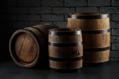 Photo of Wooden barrels on table near brick wall, closeup