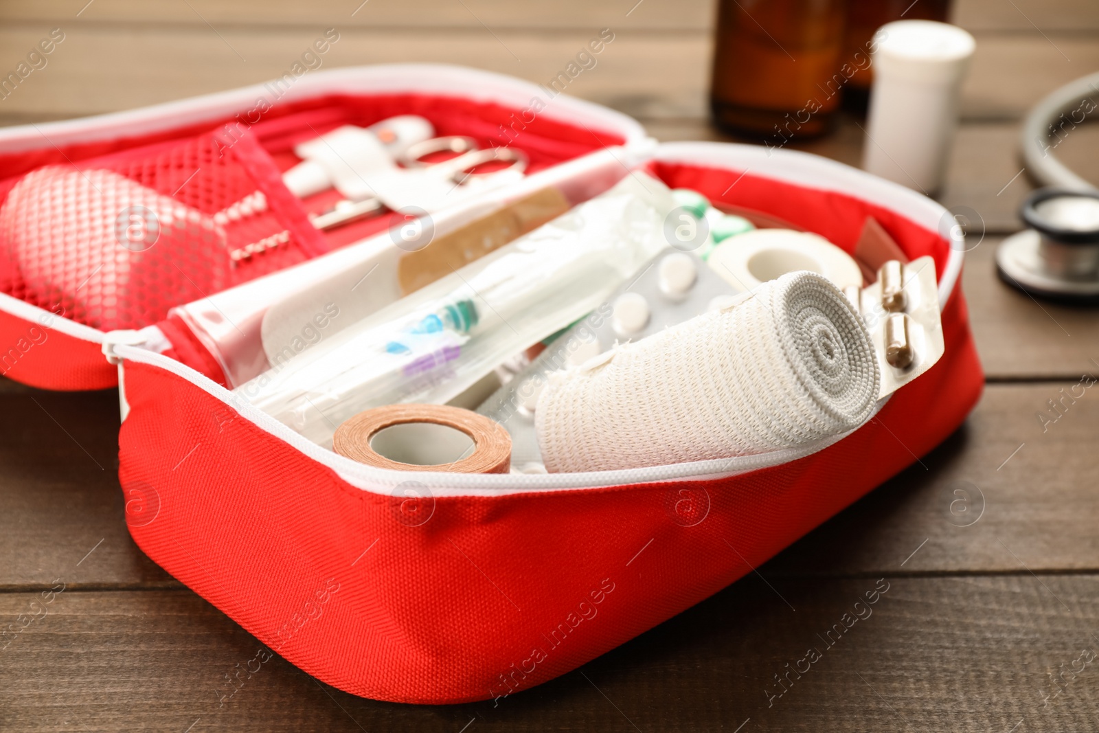 Photo of First aid kit on wooden table, closeup