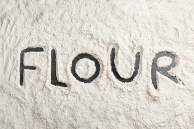 Word written on layer of flour, top view