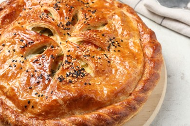 Tasty homemade pie with filling on light table, closeup