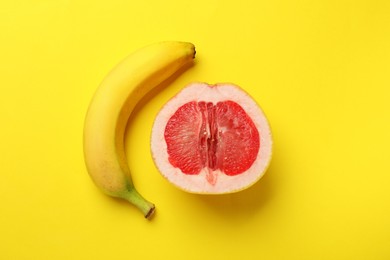 Photo of Banana and half of grapefruit on yellow background, flat lay. Sex concept
