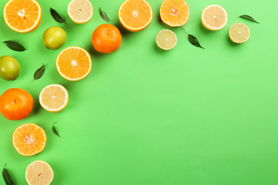 Photo of Flat lay composition with tangerines and different citrus fruits on green background. Space for text