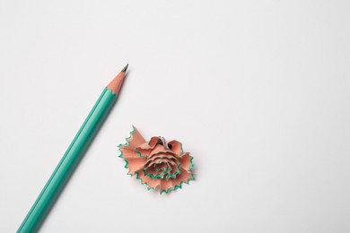 Photo of Graphite pencil and shavings on white background, flat lay. Space for text