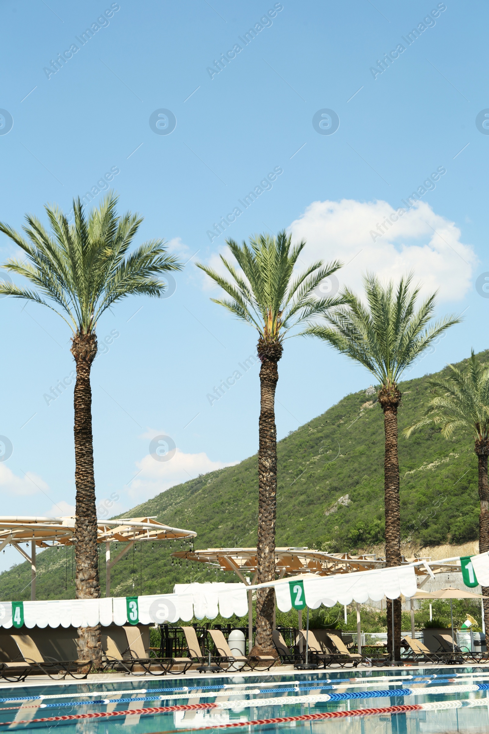 Photo of Outdoor swimming pool at luxury resort and beautiful view of mountains on sunny day