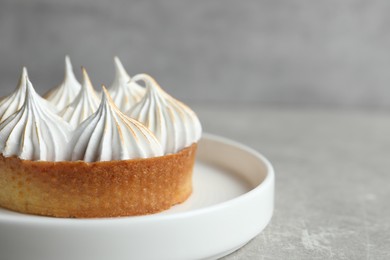 Photo of Tartlet with meringue on grey table, closeup and space for text. Delicious dessert