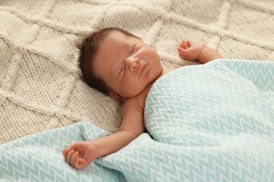 Cute newborn baby sleeping on beige blanket, closeup